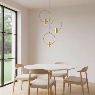 Mesa de jantar redonda branca com quatro cadeiras de madeira clara e luminária pendente dourada