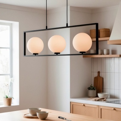 Lustre pendurado com três globos de vidro fosco branco numa cozinha clara moderna com móveis em madeira clara.