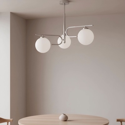 Candeeiro de teto com globos brancos sobre mesa redonda de madeira