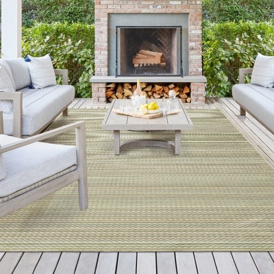 Conjunto de mobiliário de exterior com sofás, cadeira e mesa de centro numa varanda com lareira