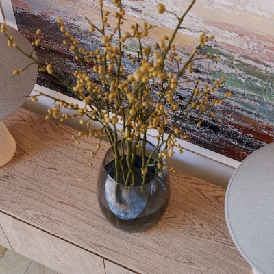 Jarro de vidro com ramos secos amarelos sobre móvel de madeira clara