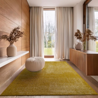 Tapete amarelo esverdeado, pufe branco, vasos cerâmicos com raminhos secos, decoração minimalista em madeira clara