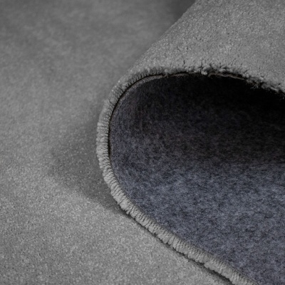 Tapete cinzento felpudo com bordado overlock ligeiramente enrolado