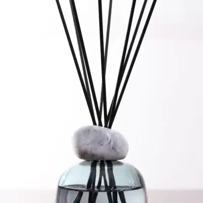 Vaso de vidro com líquido e paus pretos para aromatizador de ambiente