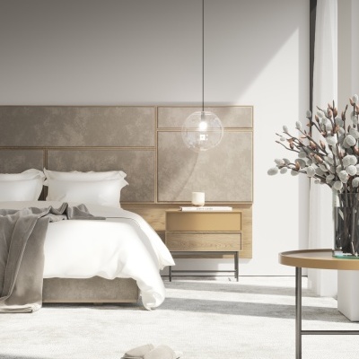 Quarto moderno com cama estofada, mesa de cabeceira em madeira e metal, candeeiro suspenso, carpete cinza e mesa com vaso de flores secas