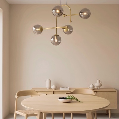 Mesa redonda de madeira clara com cadeira e aparador e candeeiro suspenso moderno