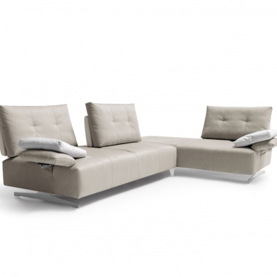 Sofá de canto moderno em pele bege com almofadas e braços reclináveis