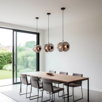 Conjunto de mesa de jantar em madeira clara com seis cadeiras cinza e três lâmpadas pendentes de vidro transparente na sala iluminada com janela grande