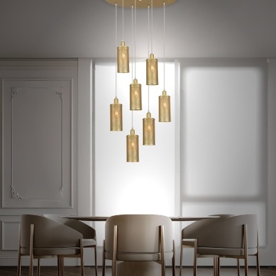Lustre moderno dourado com sete luminárias cilíndricas sobre mesa de jantar com quatro cadeiras bege