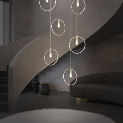 Candeeiro de teto com anéis dourados e lâmpadas LED suspensos em sala minimalista