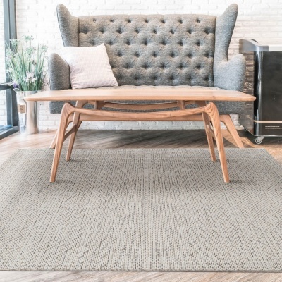 Sofá cinza com mesa de centro de madeira e tapete bege