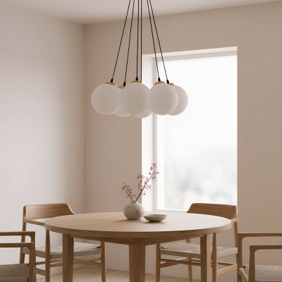 Mesa de madeira redonda com quatro cadeiras e luminária pendente com globos brancos