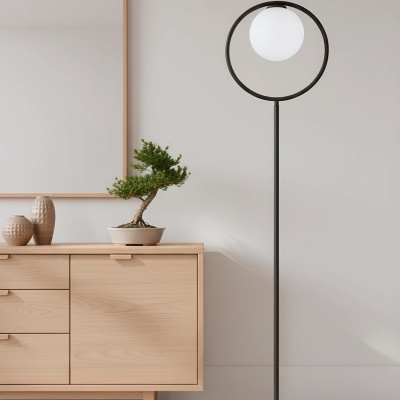 Lâmpada de pé preta com globo de luz branco ao lado de móvel em madeira clara e decoração minimalista