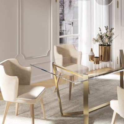 Mesa de vidro com estrutura dourada e cadeiras bege num ambiente claro e moderno