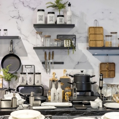 Utensílios de cozinha em metal, madeira e vidro com prateleiras e parede de mármore