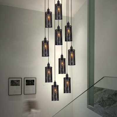 Candeeiro suspenso moderno com abajures cilíndricos pretos perfurados em escadaria interior