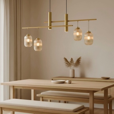 Mesa de jantar de madeira clara com bancos almofadados e candeeiro suspenso de vidro e dourado