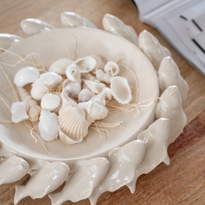 Prato decorativo de cerâmica com conchas naturais e relevos de conchas ao redor