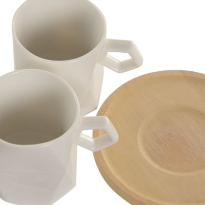 Duas chávenas brancas de cerâmica com pega hexagonal e prato de madeira claro