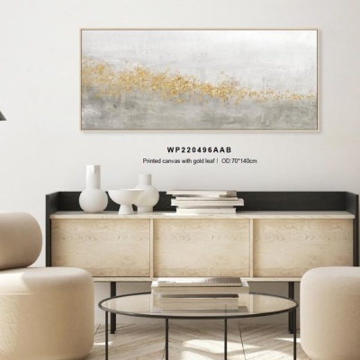 Quadro abstrato com folha de ouro pendurado sobre móvel de madeira clara em sala com cadeiras bege e mesa de vidro.