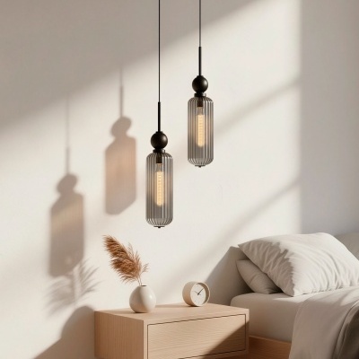 Mesa de cabeceira suspensa com vaso e relógio, cama com roupa branca e lâmpadas pendentes de vidro