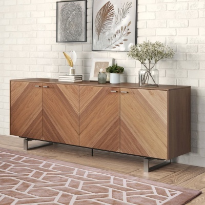 Aparador de madeira com portas de padrão geométrico em tons marrons, decorado com vasos e livros, parede branca de tijolos ao fundo