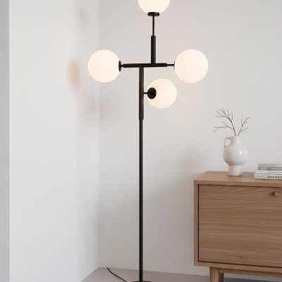 Candeeiro de pé com globos de luz brancos e estrutura preta ao lado de móvel de madeira