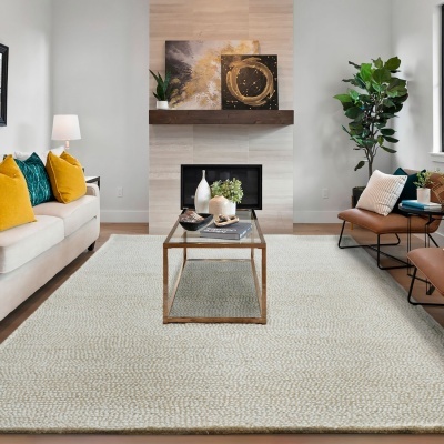 Sala de estar com tapete claro, sofá branco, almofadas coloridas, mesa de centro, lareira e poltronas marrons