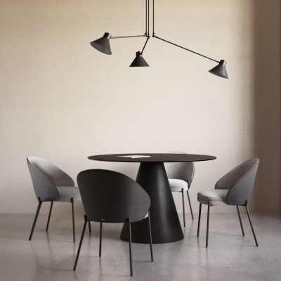 Mesa redonda preta com quatro cadeiras cinzentas e luz suspensa de três pontos em ambiente minimalista