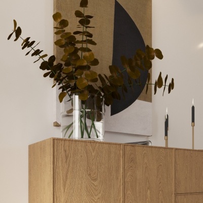 Aparador em madeira clara com vaso e pintura abstrata na parede