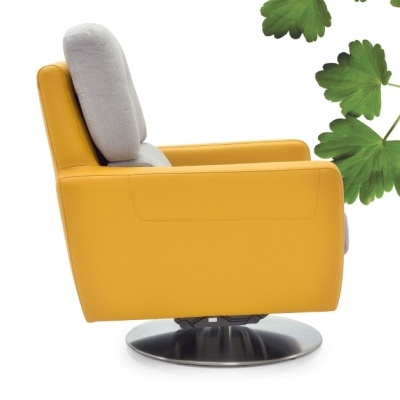 Poltrona amarela com estofado cinzento e base giratória prateada com folhas verdes ao fundo