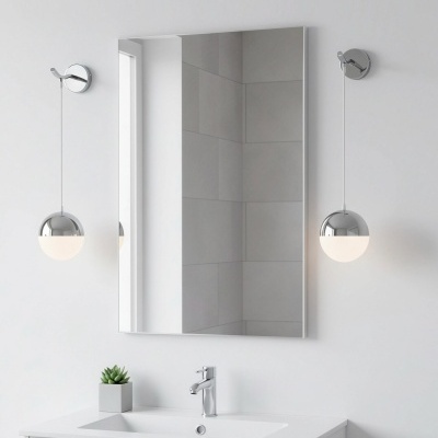 Casa de banho moderna com lavatório branco, espelho retangular e duas luminárias redondas cromadas suspensas