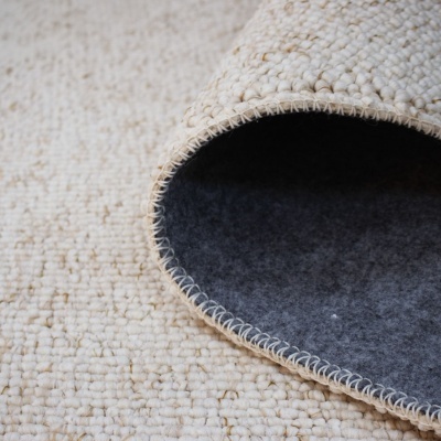 Tapete bege claro com textura de tramas grossas e verso cinza escuro felpudo