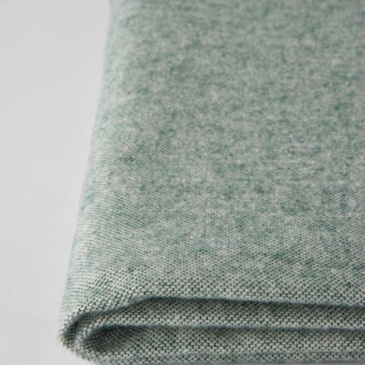 Tecido verde dobrado sobre superfície branca