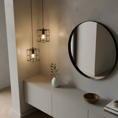 Móvel cinzento com espelho redondo, luminárias pendentes em forma de cubo e acessórios decorativos.