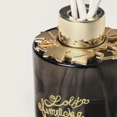 Frasco preto com tampa dourada e pauzinhos brancos para aromatizador Lolita Lempicka