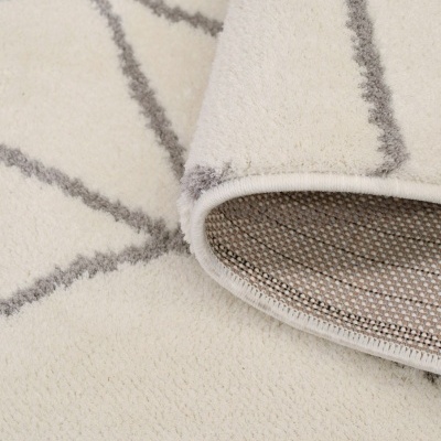 Tapete branco com padrão geométrico cinzento e verso tecido em tons bege e castanho