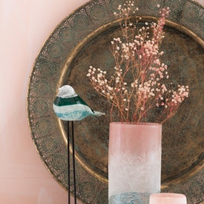 Conjunto decorativo com prato dourado, vaso de vidro com flores secas, castiçal e figura de pássaro em vidro
