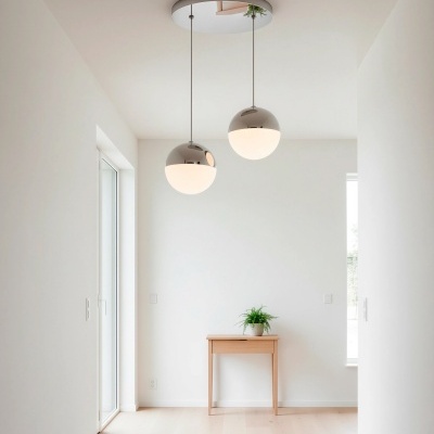 Lâmpadas de teto pendentes espaçadas sobre mesa de madeira com planta, em sala de chão e paredes claras