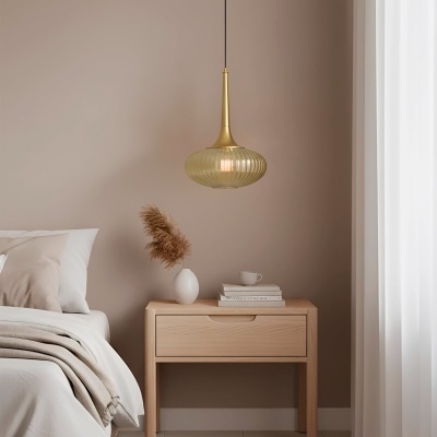 Mesa de cabeceira de madeira clara com objetos decorativos e candeeiro pendente num quarto com cama e cortinas brancas