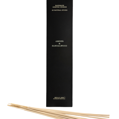 Embalagem preta de incenso com texto dourado e paus de incenso naturais à frente