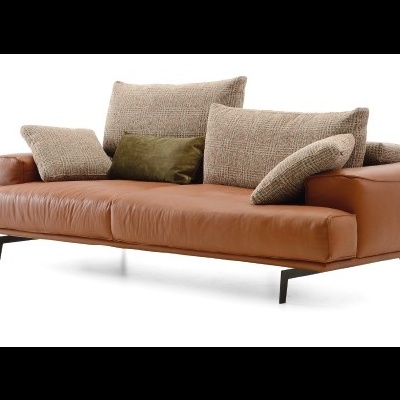 Sofá castanho em pele com almofadas bege e verde.