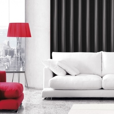 Sala com sofá branco e sofá vermelho, candeeiro vermelho e parede preta