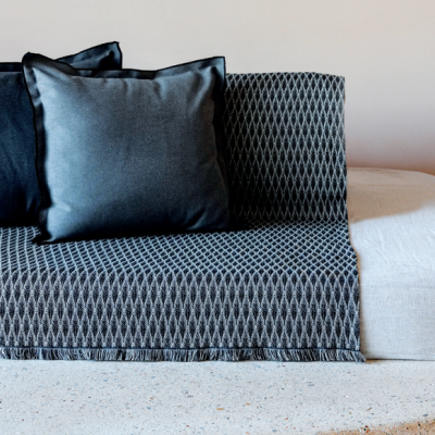 Sofá moderno com cobertura preta e branca geométrica e duas almofadas pretas