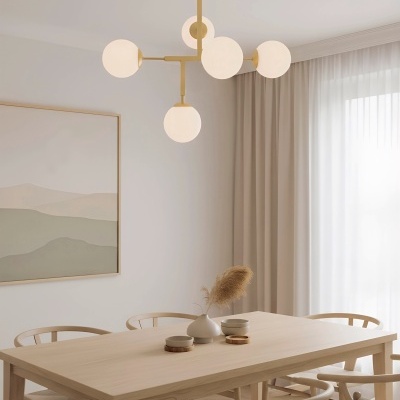 Mesa de jantar de madeira clara com cadeiras e pendente de teto com globos de luz