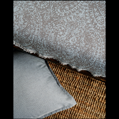 Cobertor cinza com padrão, almofada cinza e tapete de fibra natural