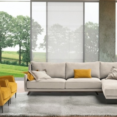 Sala com sofá de canto cinza claro e poltronas amarelas em tecido.