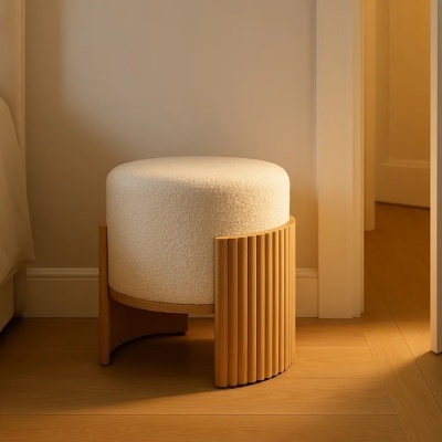 Puff redondo estofado branco com base de madeira clara em ambiente interior