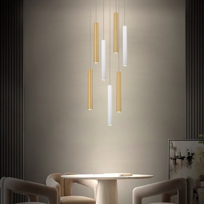 Luminária suspensa moderna com tubos dourados e brancos sobre mesa redonda branca com cadeiras bege