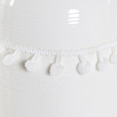 Cordão branco com bolas de franjas pendurado num vaso cerâmico branco.